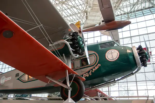 Historic aircraft display in a museum, a propeller biplane labeled 
