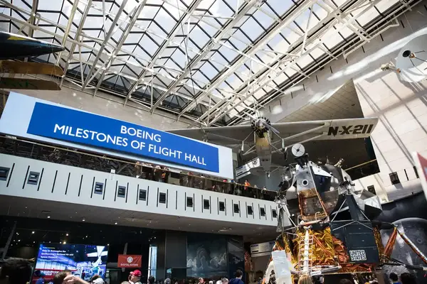 The Boeing Milestones of Flight Hall at the Smithsonian National Air and Space Museum, featuring a lunar module exhibit and an aircraft overhead