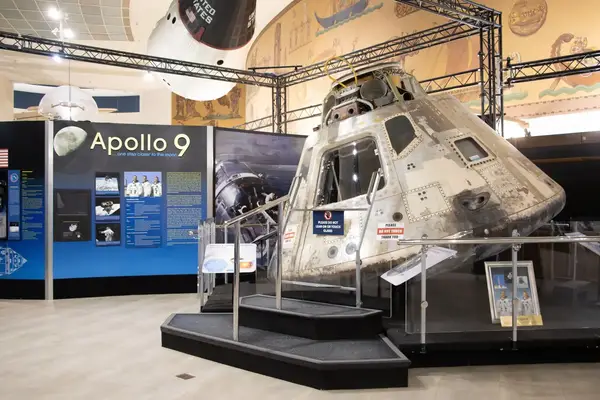 Apollo 9 command module on display at the San Diego Air and Space Museum, surrounded by informational panels and exhibits