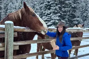 A woman feeding a horse at Lone Mountain Ranch, Montana