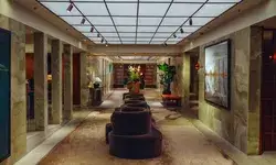 Lobby area with modern seating and artwork adorned with flowers and plants illuminated by a grid light ceiling