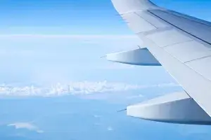 Aircraft wing on the clouds,flying background. Airplane wing and white clouds