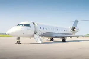 A private jet parked on an airport tarmac, stairs extended for boarding