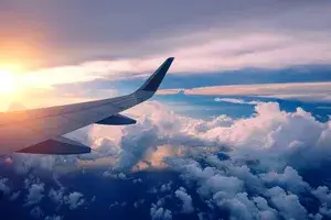 Close-up of airplane wing flying at sunrise
