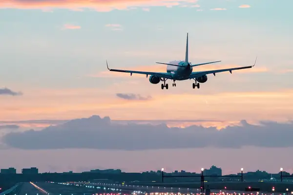 Airplane approaching runway during sunset