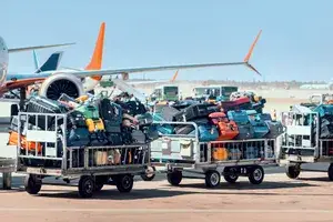 Passengers baggage in carts is waiting to be loaded onto the plane