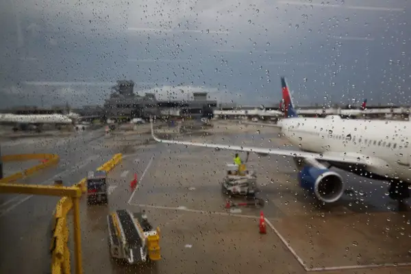 Airport tarmac scene with an airplane and wet conditions visible