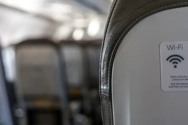 WiFi sticker on back of airplane seat with blurred seats in background