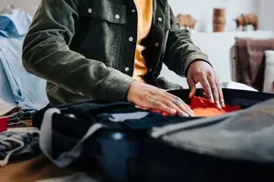 A person packing a suitcase