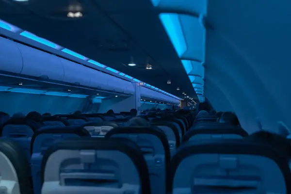 Interior of an airplane cabin at night with passengers seated