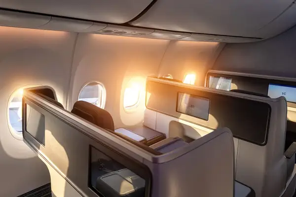 Luxury first-class airplane seating during sunset, view out the cabin windows