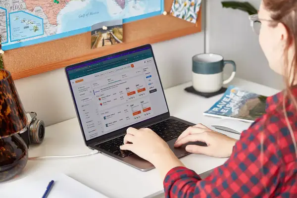A person using a laptop at a desk, shown from behind