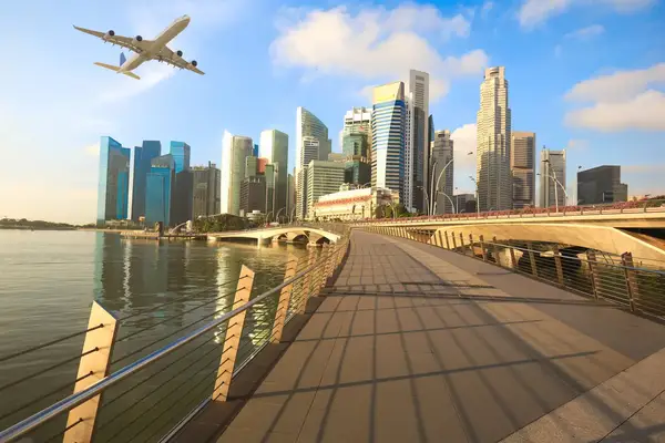 An airplane flying over a cityscape with tall buildings and a waterfront view