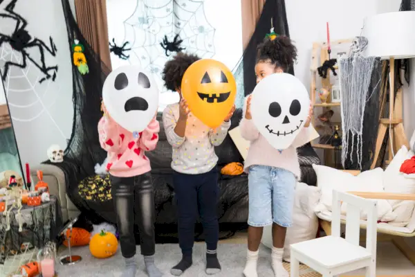 happy caucasian white and african america children getting halloween party in their house