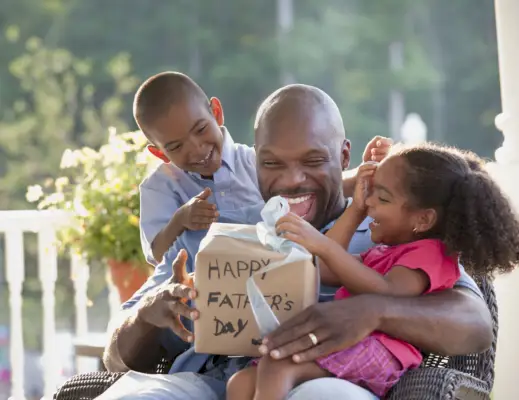 boy and girl watching father open fathers day gift
