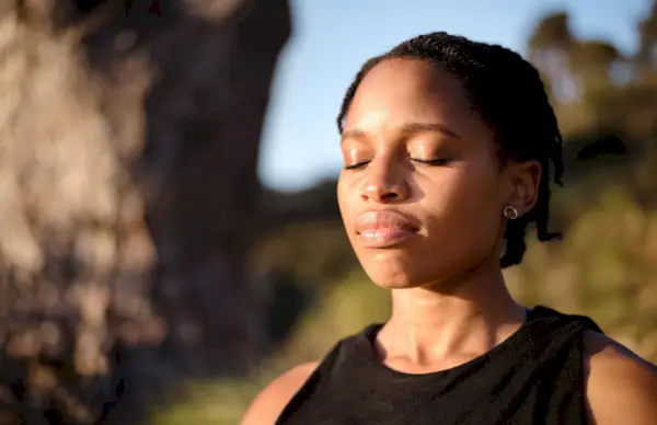 woman meditating with eyes closed