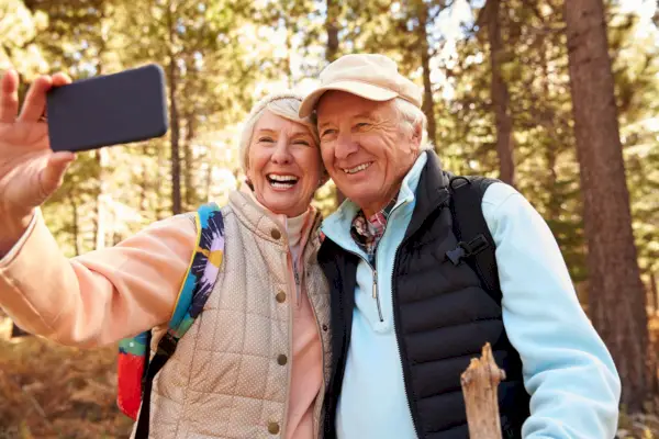 Senior couple on hike in a forest taking a selfie