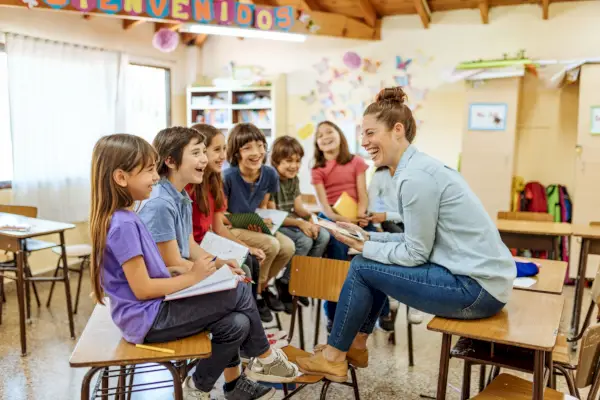 female latina teacher with hispanic kids in classroom at school
