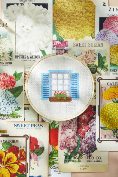 window box cross stitch on background of seed packets