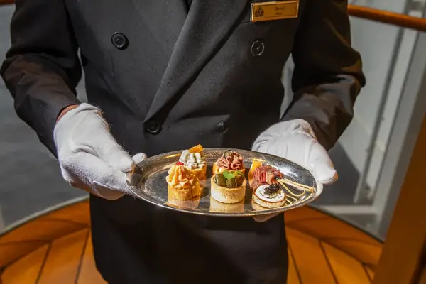 A server presenting a tray of assorted canaps
