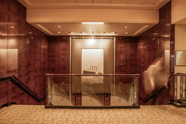 Interior with a framed illustration of the ship Queen Mary hanging on the wall visible railing in front