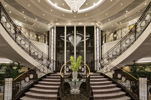 A luxurious grand staircase adorned with intricate railings and a prominent centerpiece vase