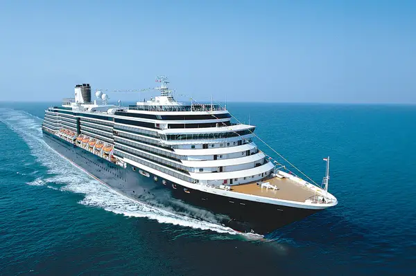 A cruise ship sailing on open water, viewed from the front left