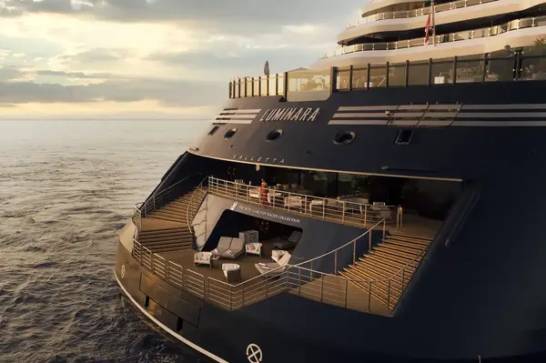 Rear view of a luxury yacht named Luminara, with a deck featuring seating and a view of the ocean