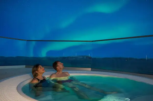 People in a Hot tub under the northern lights 