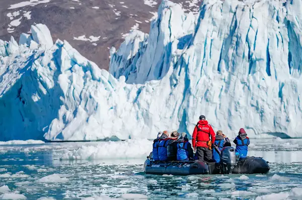 Zodiac with guests approaching glacier face, Monacobreen in Spitsbergen, Svalbard