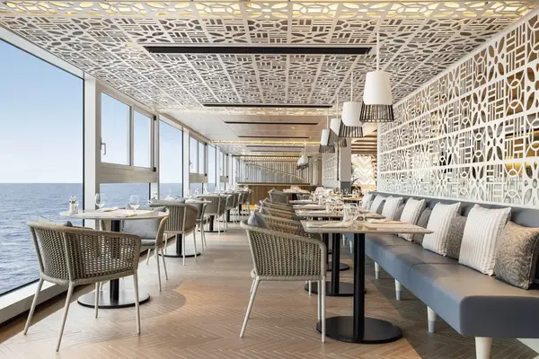 Stylish dining area with lattice decor sea view through large windows and arranged seating with tables and chairs on a cruise ship