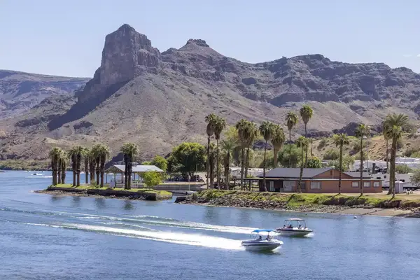 Two boats on the Colorado River in front of a town