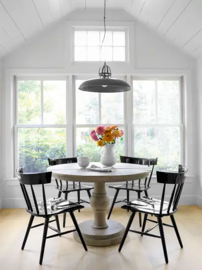 a neutral dining room with black lacquered windsor chairs