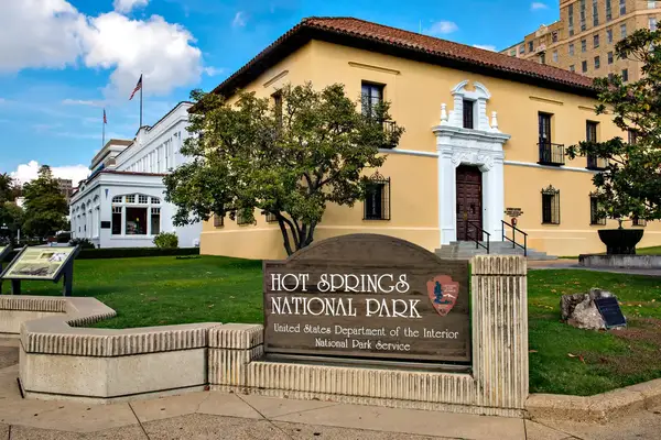 Hot Springs National Park entrance area with a sign and buildings in view