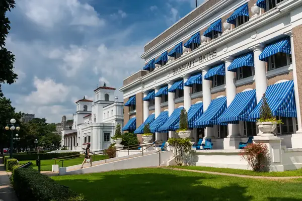 Row of buildings with classical architecture featuring columns and bluestriped awnings part of Bathhouse Row in Hot Springs National Park