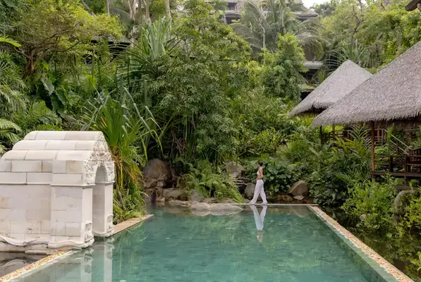 A woman walking along the edge of a pool in Koh Samui.