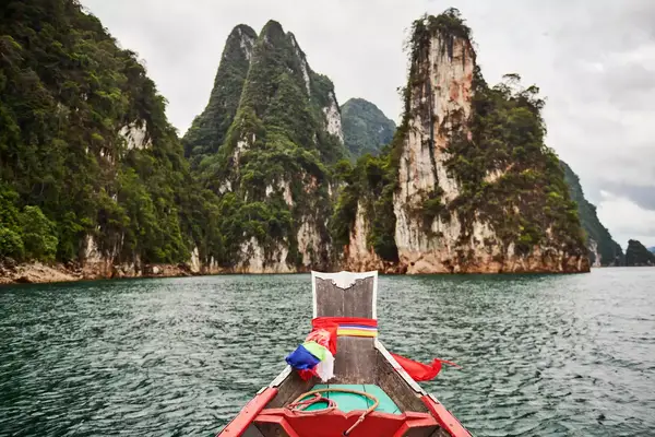 A boat approaching large limestone mountains