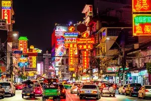 night shot of busy street with bright neon signs in bangkok