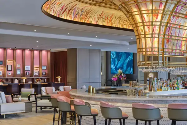 A luxury hotel bar, featuring a glass artwork canopy over the bar