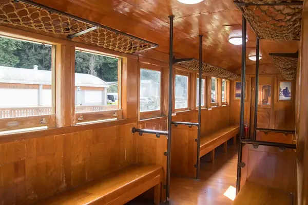 Interior of a wooden carriage with seating and windows, part of the Alishan Forest Train in Taiwan