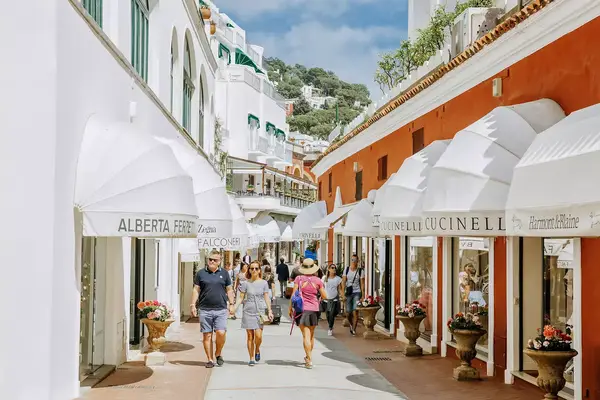 People walk on a street lined with shops in Capri