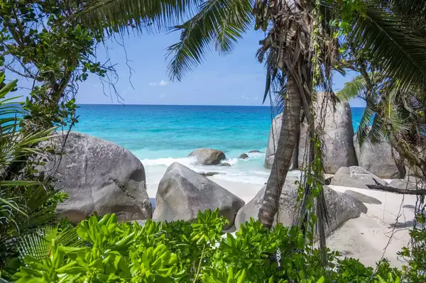 View of North Island, Seychelles beach with boulders, white sand, and blue water.