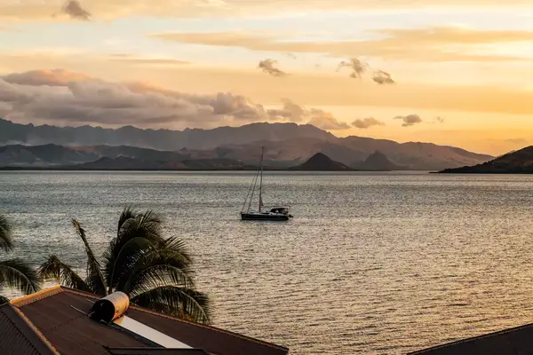 A sailboat off the coast of Fiji at sunset