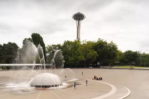 Kids playing in a fountain at the Science Center with the Space Needle in the background