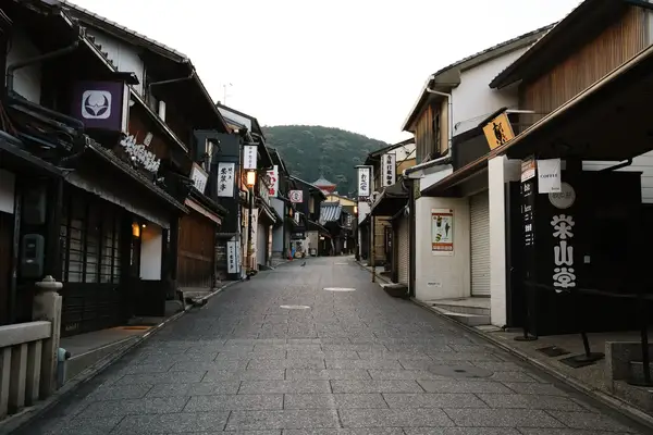 A traditional Japanese street in Kyoto with wooden buildings and signs