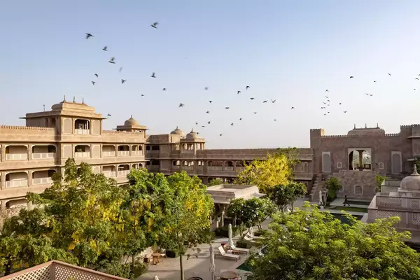 Birds fly over the Six Senses Fort Barwara resort