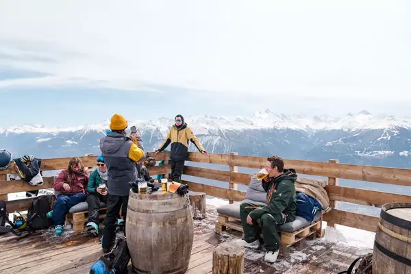 The apres-ski scene on the terrace of a ski slope restaurant in Switzerland