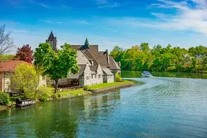 A boat sails past stone houses along Seneca Canal in Seneca Falls, New York
