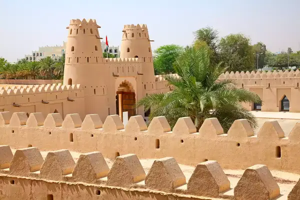Al Jahili Fort with palm trees and surrounding walls, a historic structure in Al Ain, Abu Dhabi.