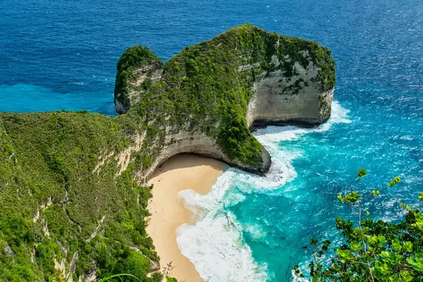 Aerial view of a beach surrounded by high cliffs and turquoise ocean water